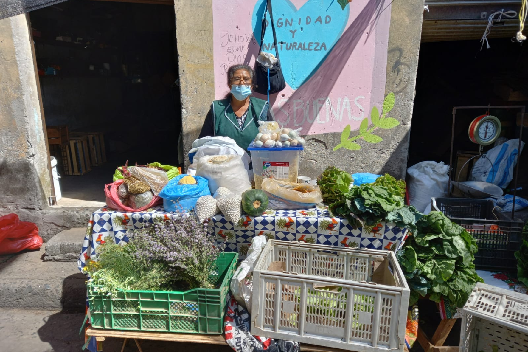 a woman standing in front of a table with produce